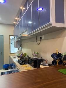 a kitchen with blue cabinets and a counter top at Ana Homestay in Batu Pahat