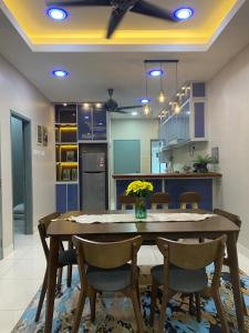 uma cozinha com uma mesa de jantar e cadeiras em Ana Homestay em Batu Pahat