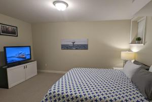 a bedroom with a bed and a flat screen tv at Jimmy B&B in Surrey