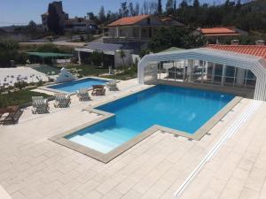a large swimming pool with a patio and a house at 9Arches in Vila Nova de Poiares