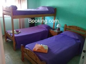 two bunk beds in a room with purple sheets at Sueños Cumplidos Chascomús in Chascomús