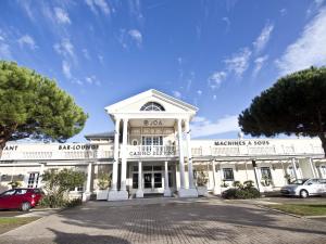 Un edificio blanco con un coche aparcado delante. en Appartement T2 proche plage avec loggia et un animal admis - FR-1-92-649, en La Pironnière