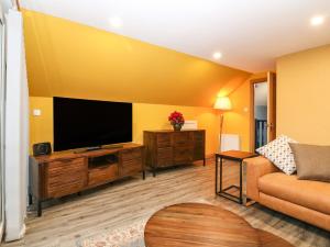 a living room with a flat screen tv and a couch at The Cavern at the Tavern in Blairgowrie