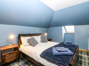 um quarto com uma cama com uma parede azul em The Cavern at the Tavern em Blairgowrie