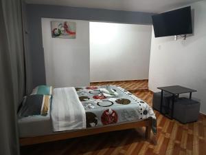 a bedroom with a bed and a table in it at Tumalki Rooms in Trujillo