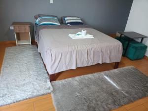 a bedroom with a bed with two rugs on it at Tumalki Rooms in Trujillo