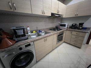 cocina con lavadora y fregadero en Résidence lagar, en Kenitra