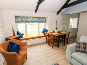 a living room with a table and chairs and a window at Bluebell Cottage in Tenby