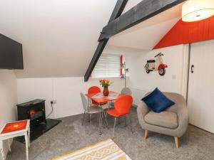 uma sala de estar com uma mesa e cadeiras e uma televisão em Clementine Cottage em Tenby