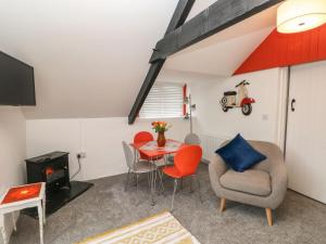 a living room with a table and chairs and a tv at Clementine Cottage in Tenby