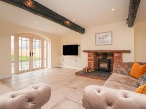 a living room with a couch and a fireplace at Meadowside Barn in Preston