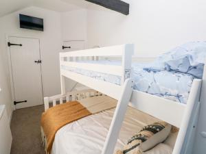 a white bunk bed in a white room with a bunk bed at Bluebell Cottage in Tenby