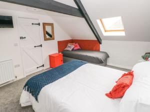 a attic bedroom with a bed and a window at Clementine Cottage in Tenby