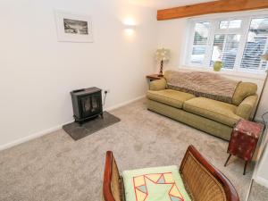 a living room with a couch and a stove at Rosemary Cottage in Tenby