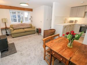a living room with a table and a kitchen at Rosemary Cottage in Tenby