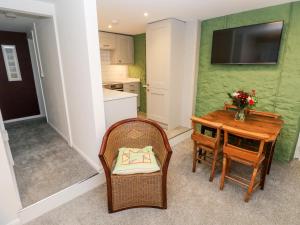 a small kitchen with a table and chairs and a television at Rosemary Cottage in Tenby +21 photos