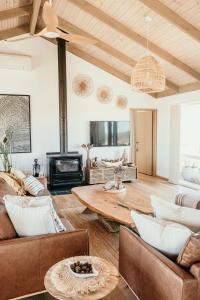 a living room with a couch and a table at Sunsets on Martyrs Coastal Luxury Beach House Peterborough in Peterborough