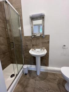 uma casa de banho com um lavatório e um chuveiro em The Chapel Guest House em St Austell