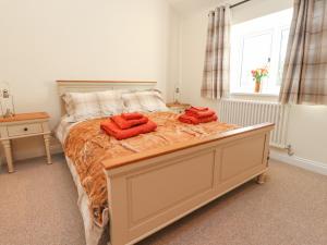 a bedroom with a bed with two red pillows on it at The Byre in Preston