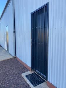 eine offene Tür eines Gebäudes mit einem Gitter in der Unterkunft Morros Place in Hay