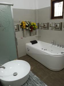 a bathroom with a tub and a toilet and flowers at Airport Dulux Green Villa in Minuwangoda