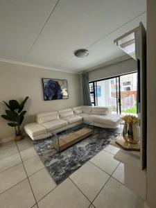 The Blyde Riverwalk Estate, Crystal Lagoon, Pretoria east في بريتوريا: غرفة معيشة مع أريكة وطاولة