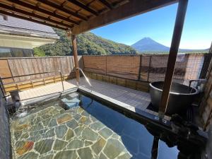 a swimming pool with a tub and a view of a mountain at Shoji Lake Hotel in Fujikawaguchiko