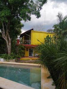 een geel huis met een zwembad ervoor bij Casita de campo in Valladolid