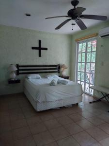 een slaapkamer met een bed met een kruis aan de muur bij Casita de campo in Valladolid