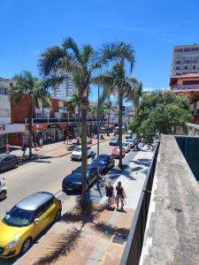 a group of people walking down a street with palm trees at Apartamento sobre Gorlero in Punta del Este
