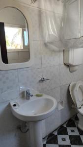 ein Badezimmer mit einem Waschbecken, einem WC und einem Spiegel in der Unterkunft Apartamento sobre Gorlero in Punta del Este