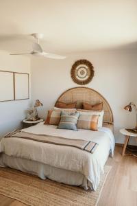 a bedroom with a large bed with pillows at Sunsets on Martyrs Coastal Luxury Beach House Peterborough in Peterborough