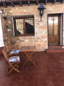 un patio con una mesa y 2 sillas y una puerta en La casita, en Baños de la Encina