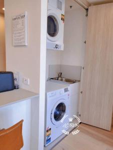 lavadero con lavadora y fregadero en City View Lovely 1BD Apartment @ CBD, en Canberra
