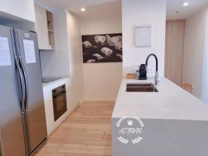 a kitchen with a refrigerator and a counter top at City View Lovely 1BD Apartment @ CBD in Canberra