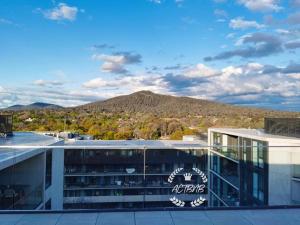 an office building with a mountain in the background at City View Lovely 1BD Apartment @ CBD in Canberra