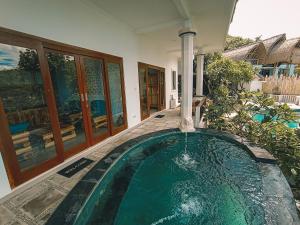 een zwembad in het midden van een huis bij Kalimaja Amed Villa in Ambat