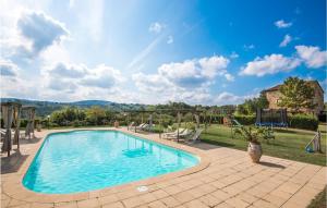 a large swimming pool in a yard with a patio at Awesome Home In Montaione With House A Panoramic View in Montaione