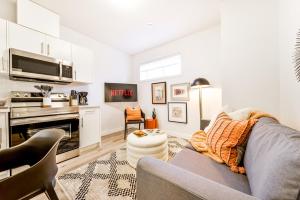 a living room with a gray couch and a kitchen at Cozy Nordic Utopia, Bsmt Suite near WEM & DT, King Bed, WiFi in Edmonton