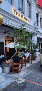 a group of people sitting at a table outside a restaurant at The Manor by Mingle in Kuala Lumpur