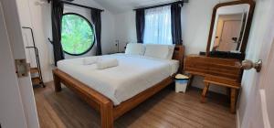 The Nidhra Boutique Resort في بان تاي: غرفة نوم مع سرير مع مرآة وخزانة