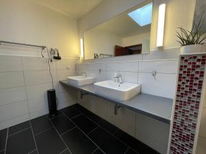 a bathroom with two sinks and a mirror at Kingfisher-Ferienhaus in Westerdeichstrich +25 photos