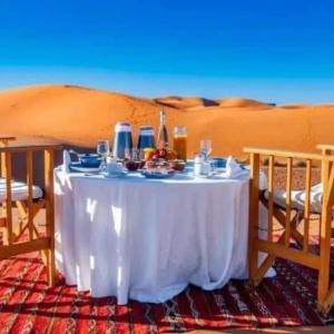a table in the middle of the desert at Family Luxury Glamping in Merzouga