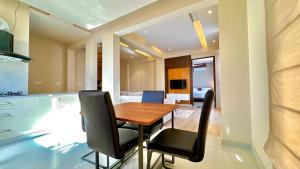 穆里的住宿－Ahmed Suites，厨房以及带木桌和椅子的用餐室。
