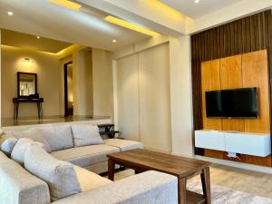 sala de estar con 2 sofás y TV de pantalla plana en Ahmed Suites, en Murree