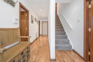 una escalera en una casa con paredes blancas y suelo de madera en The Keep at Craigiehall en Edimburgo