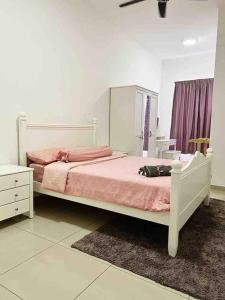 ein Schlafzimmer mit einem weißen Bett mit einer rosa Decke in der Unterkunft Homestay Sophea Cottage in Sri Sendayan in Labu