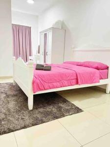 1 dormitorio con 1 cama con manta rosa en Homestay Sophea Cottage in Sri Sendayan en Labu
