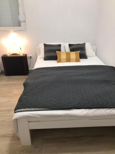 a large bed with a black and white comforter at Holiday home “Olive” in Župa