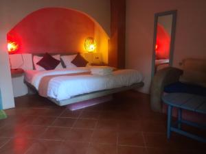 a bedroom with a large bed with a red headboard at Pandora By Jida Lifestyle Hotel in Chaweng